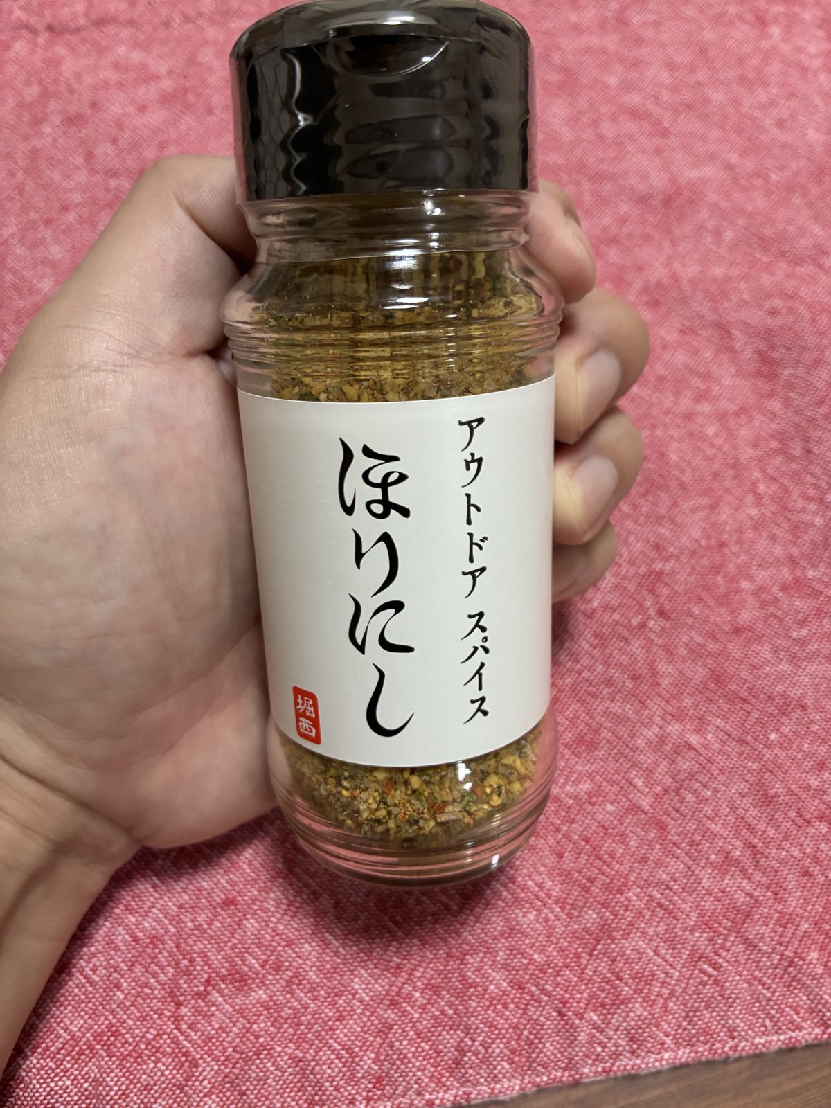 ほりにし アウトドアスパイスのボトルを手に持った正面の写真