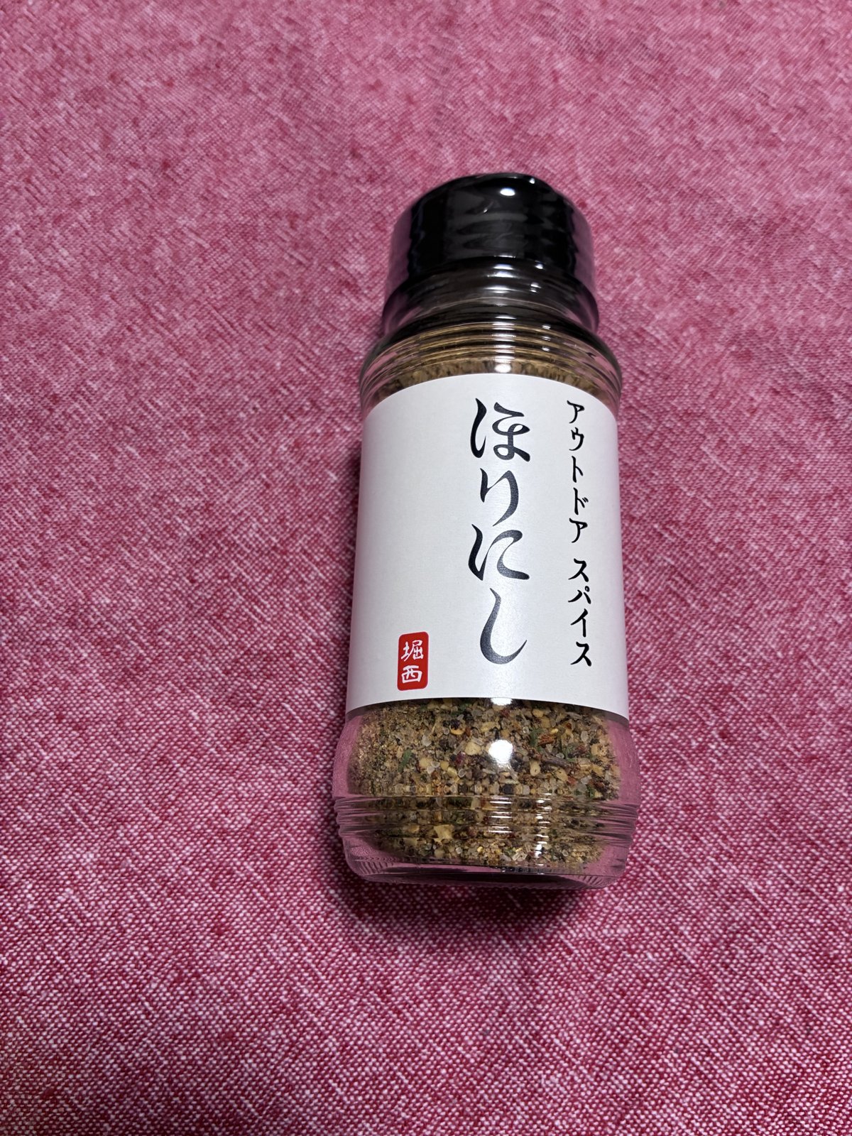 ほりにし アウトドアスパイスのボトルを机に置いて撮影した写真
