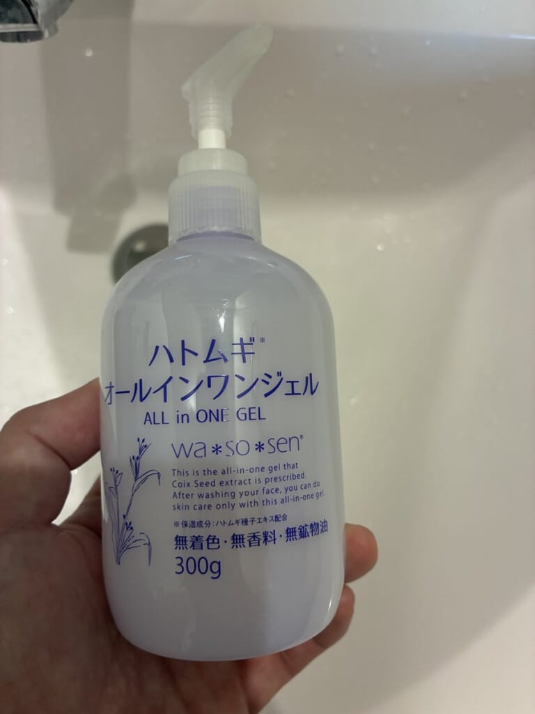 自分が今使っている、ハトムギのオールインワンジェルのボトルを洗面台で手に持って撮影した写真