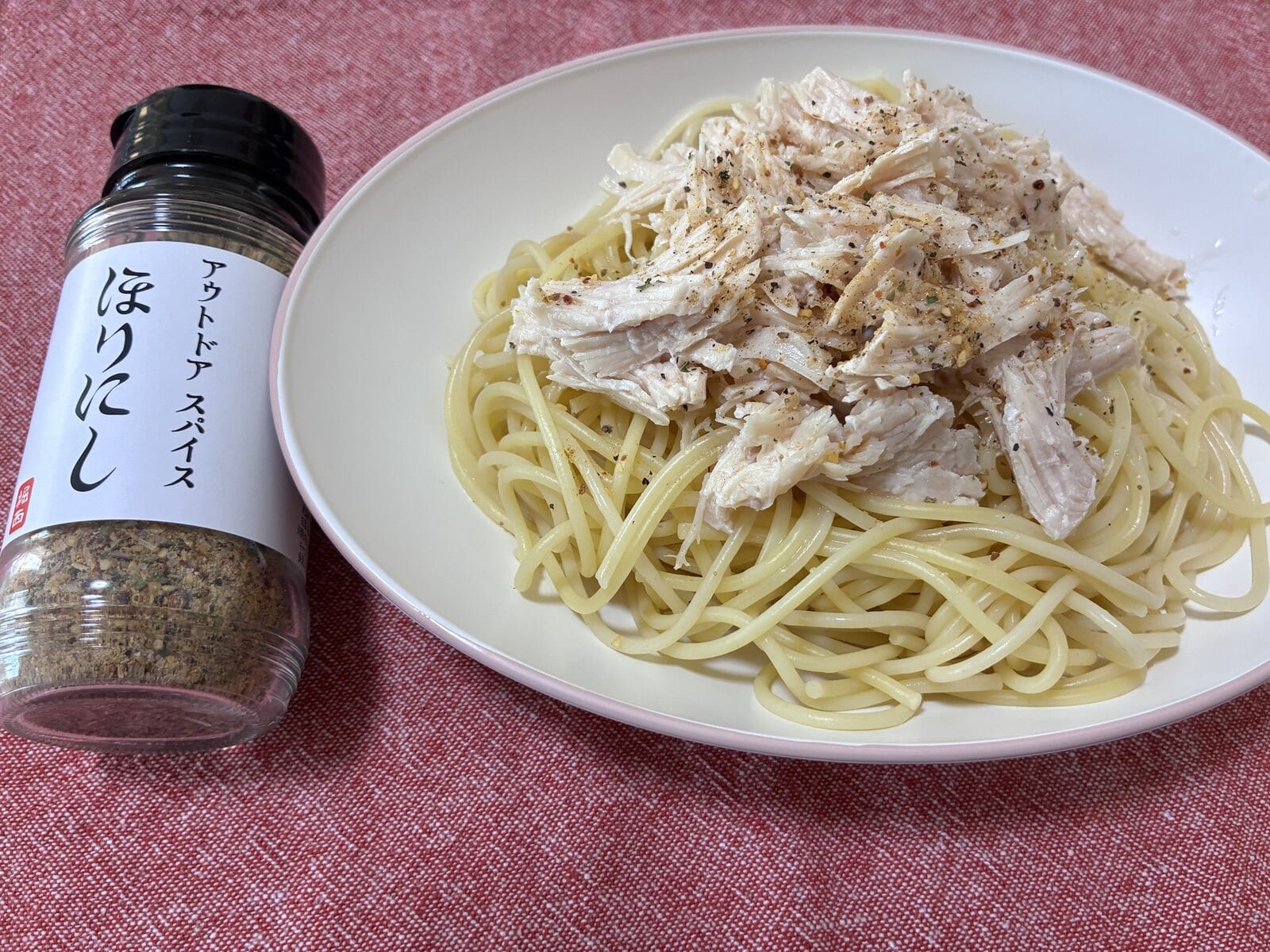 ほりにしの瓶の横に置いた、ミート21のサラダチキンを乗せたパスタの写真